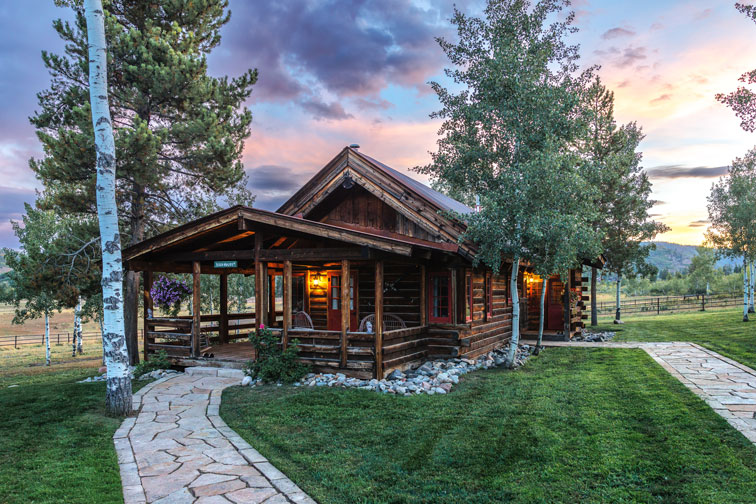 A stone pathway leads up to this cozy guest cabin with rustic charm at The Home Ranch in Colorado.