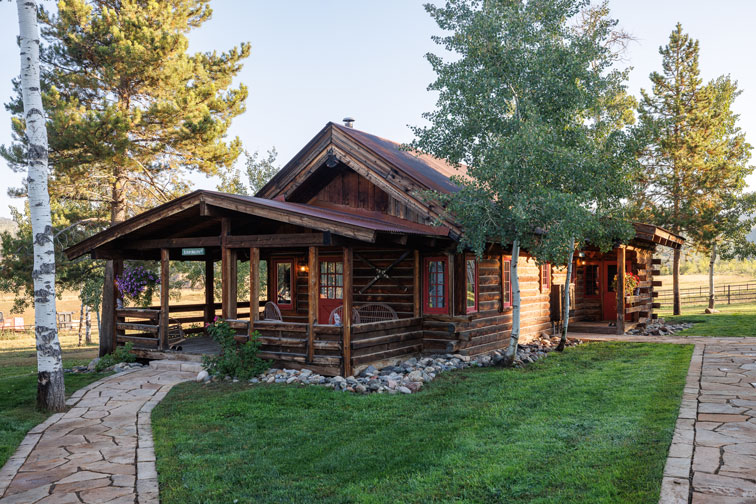 Exterior and grounds of a cozy guest cabin with rustic charm at The Home Ranch in Colorado.