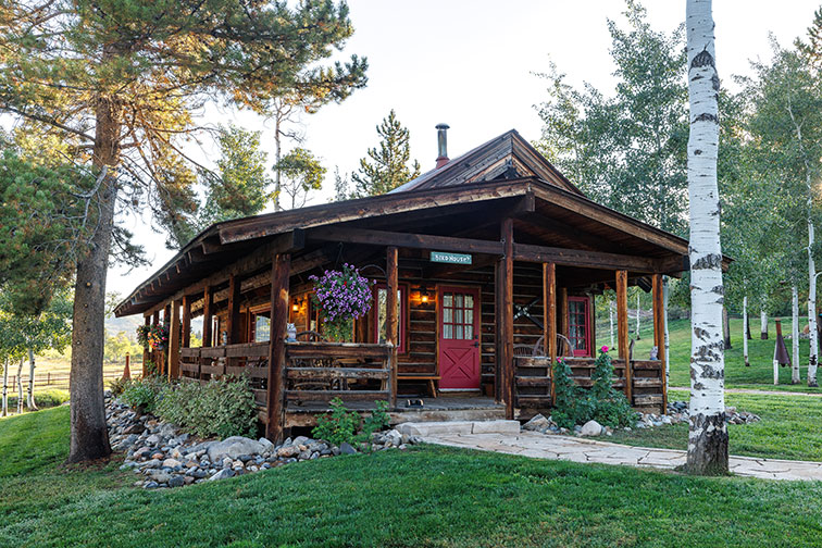 Exterior and grounds of a cozy guest cabin with rustic charm at The Home Ranch in Colorado.