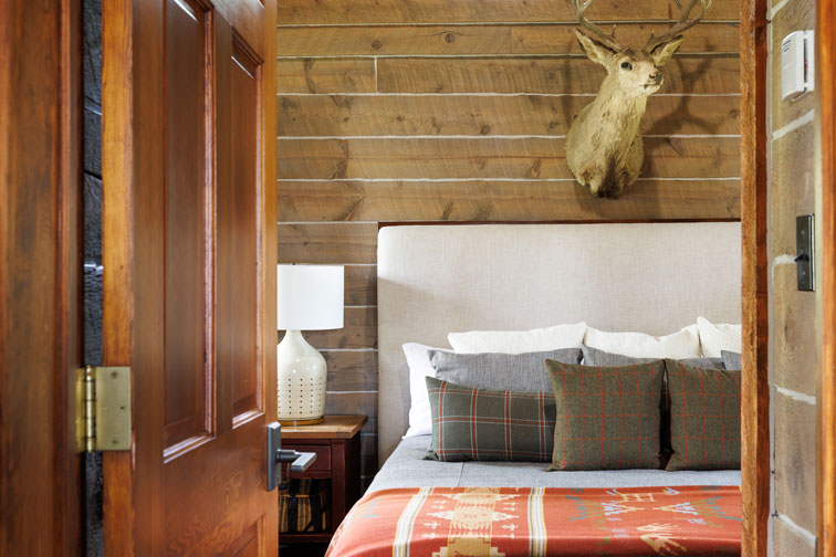 The cozy bedroom of a guest cabin at The Home Ranch in Colorado.