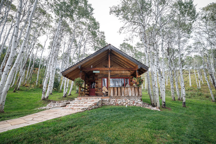 Exterior of a cozy hideaway cabin at The Home Ranch in Colorado.