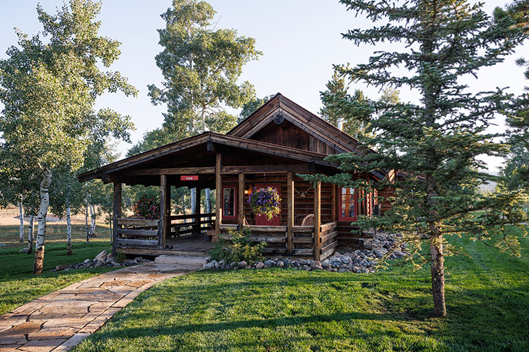 Exterior and grounds of a luxury guest cabin with traditional feel at The Home Ranch.