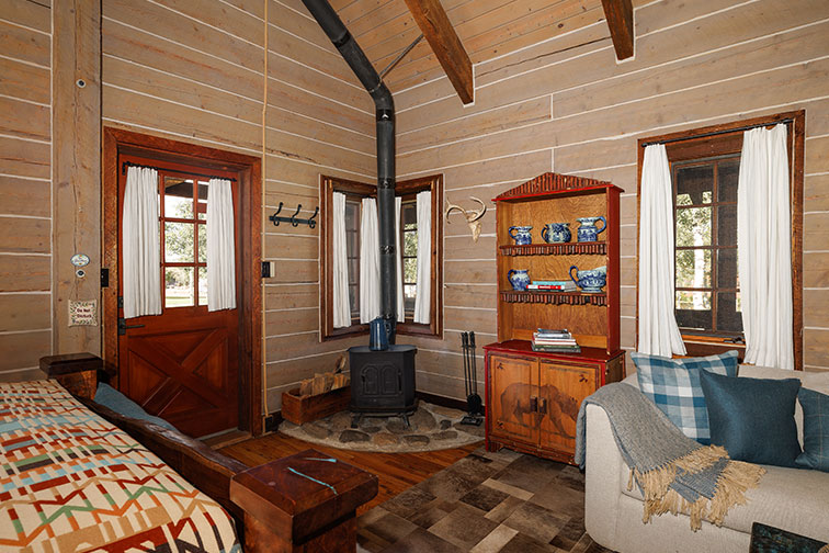 Wood burning fireplace and interior of a cozy guest cabin at The Home Ranch.