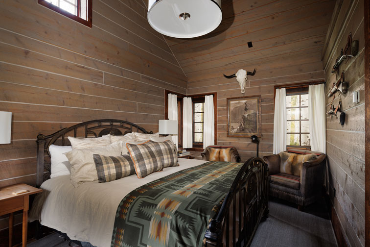 The bedroom area of a romantic guest cabin at the Home Ranch in Colorado.