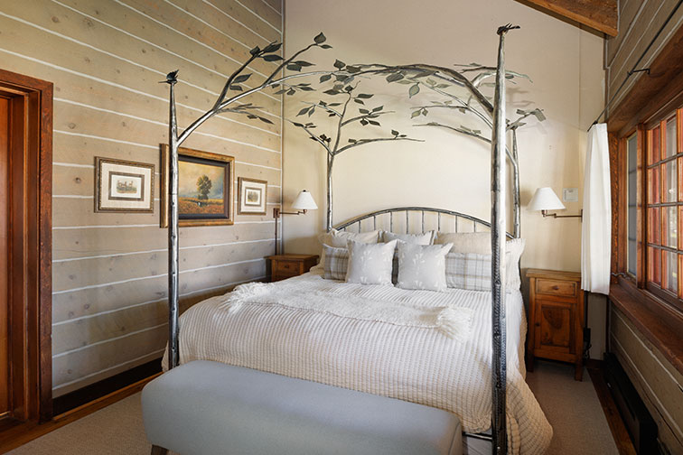 Canopy bed in a cozy bedroom of a guest cabin at The Home Ranch in Colorado.