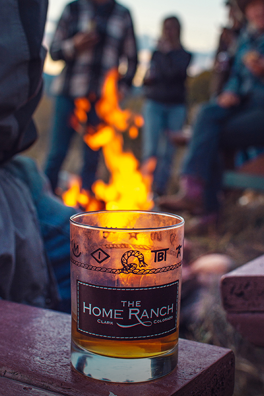 Enjoying a cocktail fireside at The Home Ranch luxury ranch in Clark, Colorado.