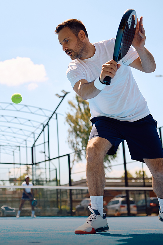 A man playing paddle tennis at The Home Ranch in Clark, Colorado.