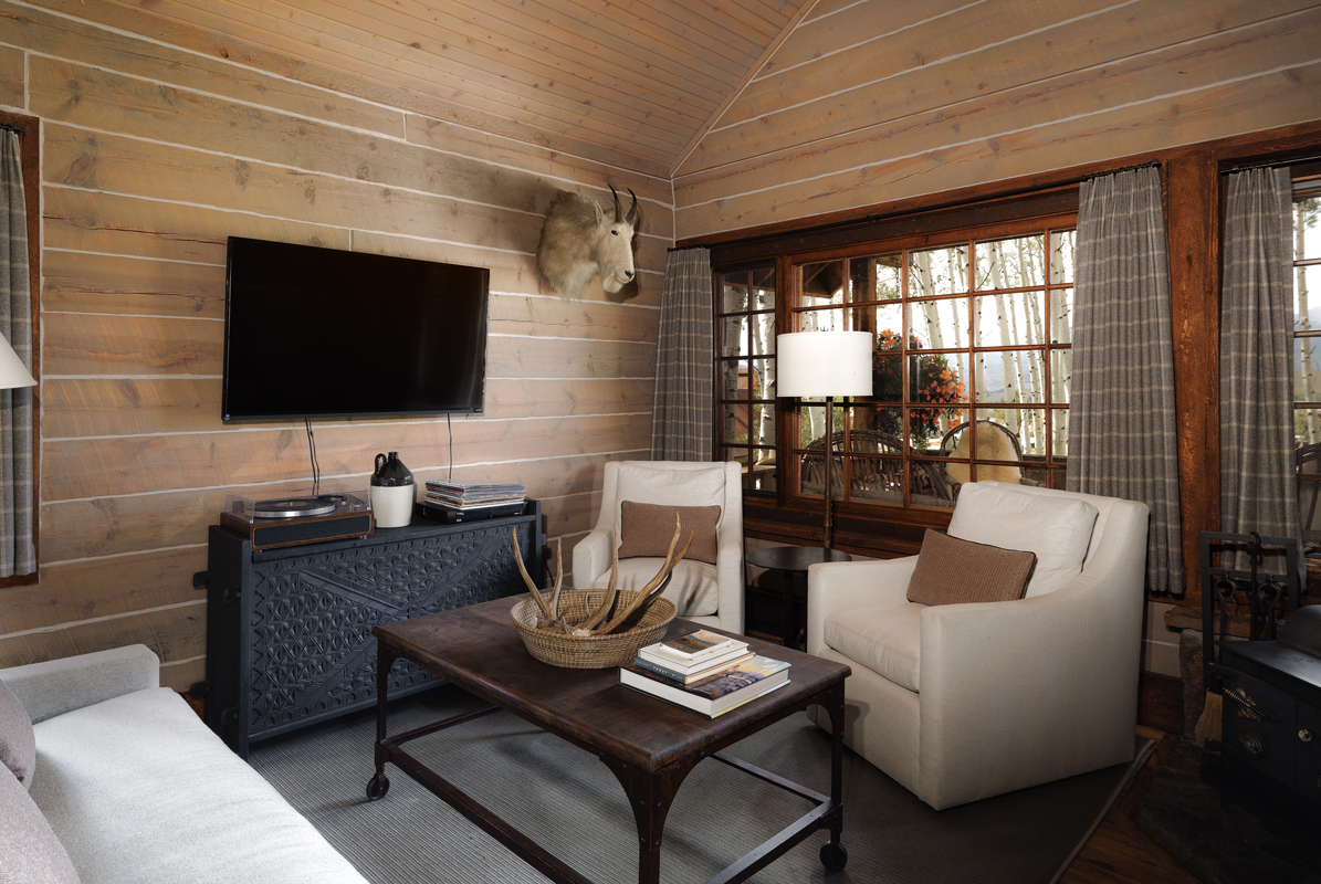 A serene living area, awash in beiges and grays in the Compromise guest cabin at The Home Ranch in Colorado.