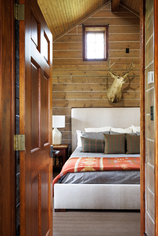 The serene bedroom of the Compromise guest cabin at The Home Ranch in Colorado is awash in earth tones, including its nature-inspired décor.