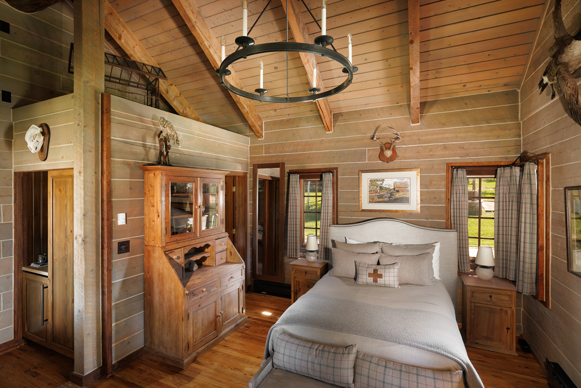 The hanging chandelier warms the wood accented walls of the Birdhouse, a cozy guest cabin at The Home Ranch in Colorado.