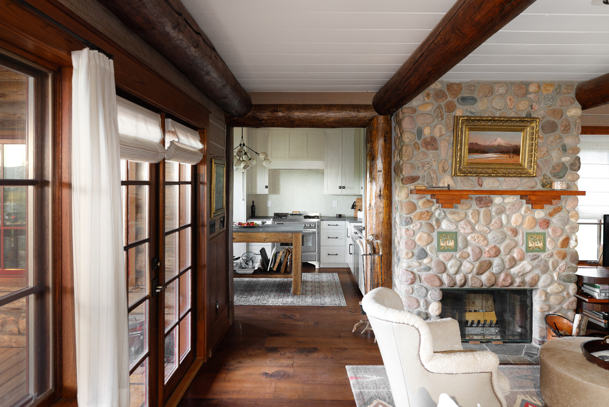 A stone fireplace and wood floors complete the cozy vibe of this guest cabin at The Home Ranch in Colorado.