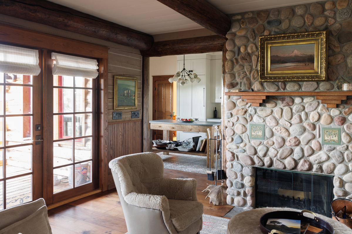 A stone fireplace and wood floors complete the cozy vibe of this guest cabin at The Home Ranch in Colorado.