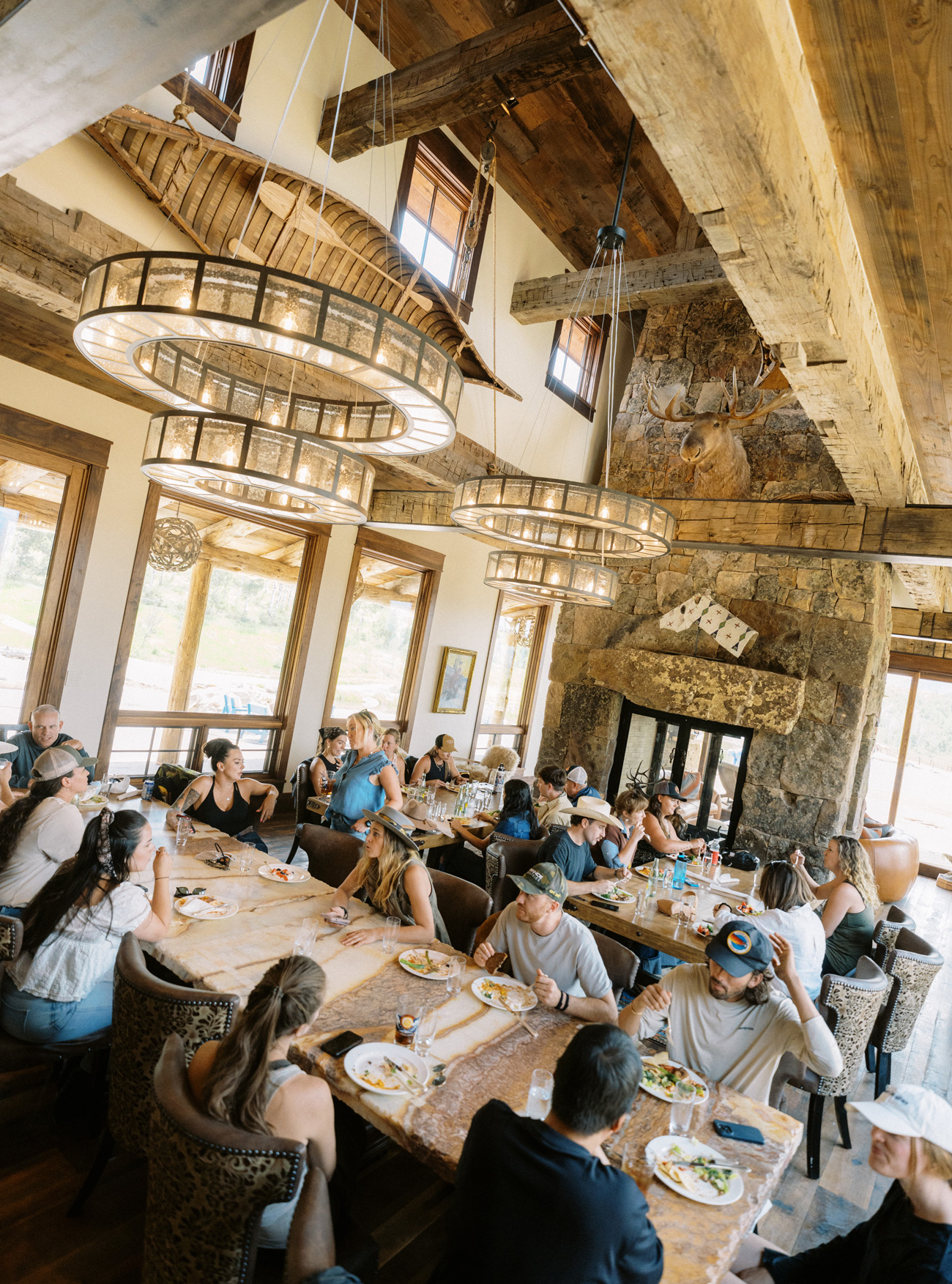 large group of people sitting around tables inside dining and talking